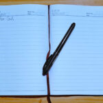 Open journal with handwritten words “Dear God…” beside a pen, symbolizing gratitude journaling as worship to God.