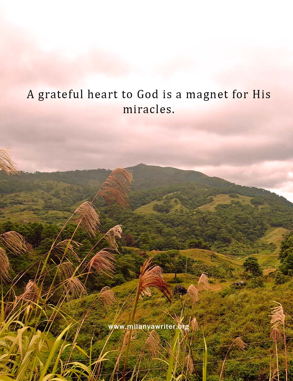 Inspirational Christian quote “A grateful heart to God is a magnet for His miracles” displayed over a scenic local mountain view with clouds and blue sky, symbolizing faith, gratitude, and God’s blessings.