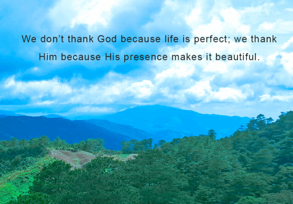 A beautiful mountain with trees under a clear blue sky, featuring the quote: “We don't thank God because life is perfect; we thank Him because His presence makes it beautiful.”